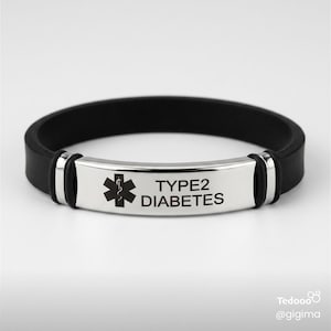 May include: A black silicone medical alert bracelet featuring a polished silver-tone metal plate. The plate is engraved with a black Star of Life medical symbol and the text TYPE2 DIABETES in a clear, sans-serif font, secured by silver-tone accents.