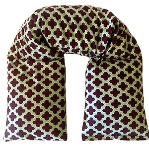 May include: A U-shaped neck pillow with a burgundy and green geometric pattern. The pillow is filled with buckwheat hulls and is designed to provide support for the neck and shoulders.