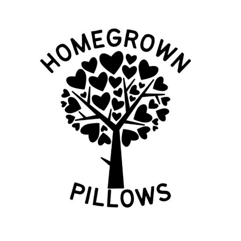 Puede incluir: Logotipo en blanco y negro que presenta un &aacute;rbol con hojas en forma de coraz&oacute;n. Las palabras "HOMEGROWN" est&aacute;n arqueadas sobre el &aacute;rbol, y "PILLOWS" est&aacute; escrito debajo. El dise&ntilde;o es simple y limpio, adecuado para la marca.