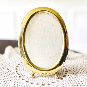 Vintage brass oval picture frame with round feet