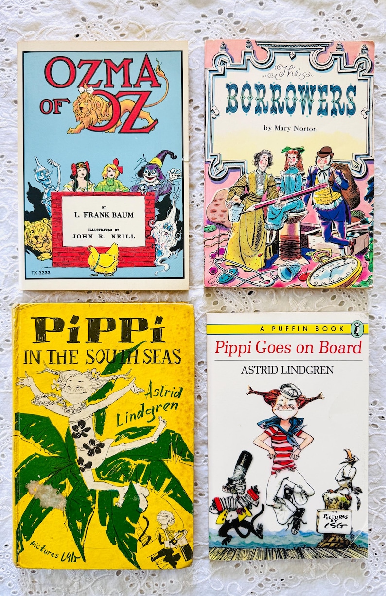 Puede incluir: Cuatro libros infantiles antiguos con portadas ilustradas: Ozma of Oz de L. Frank Baum, The Borrowers de Mary Norton, Pippi in the South Seas de Astrid Lindgren y Pippi Goes on Board de Astrid Lindgren, dispuestos en una cuadr&iacute;cula.