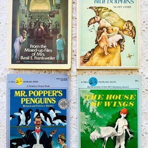Puede incluir: Cuatro libros de bolsillo vintage Dell Yearling con portadas ilustradas: From the Mixed-up Files of Mrs. Basil E. Frankweiler, Island of the Blue Dolphins, Mr. Popper's Penguins y The House of Wings, cada uno con ilustraciones coloridas.