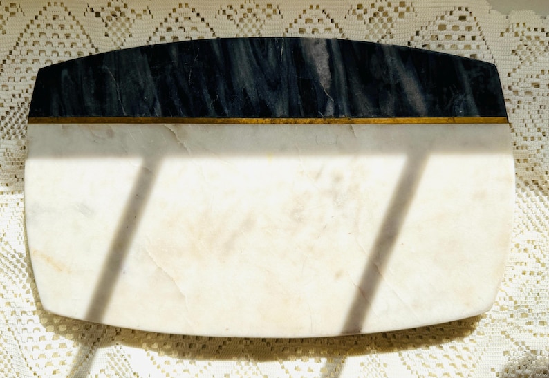 May include: Rectangular marble serving board with a dark blue and white marbled top section, separated by a thin gold band from the white marble base. The board has rounded corners and is ideal for serving appetizers.
