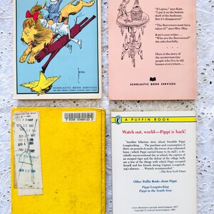 Puede incluir: Cuatro libros de bolsillo vintage dispuestos en una cuadr&iacute;cula. Arriba a la izquierda, una ilustraci&oacute;n colorida de personajes del Mago de Oz. Arriba a la derecha, una cubierta rosa p&aacute;lido con texto y un dibujo lineal. Abajo a la izquierda, una cubierta amarilla lisa con una tarjeta de pr&eacute;stamo. Abajo a la derecha, una cubierta blanca con texto negro y el logotipo de Puffin Books.