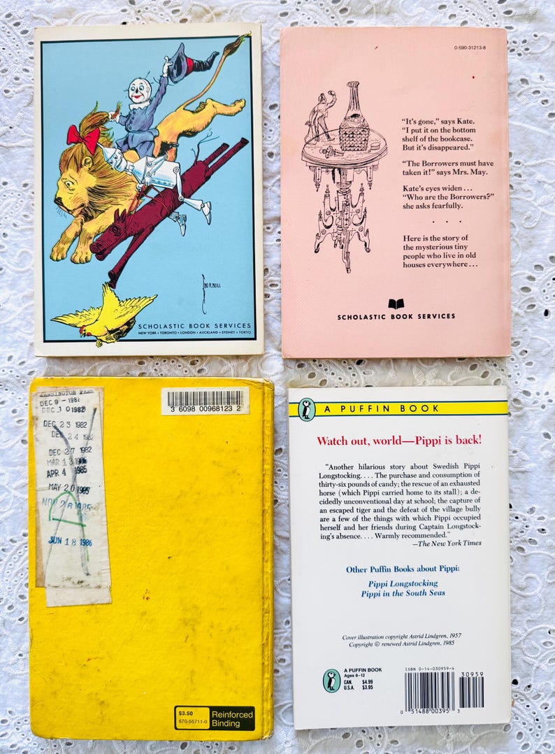Puede incluir: Cuatro libros de bolsillo vintage dispuestos en una cuadr&iacute;cula. Arriba a la izquierda, una ilustraci&oacute;n colorida de personajes del Mago de Oz. Arriba a la derecha, una cubierta rosa p&aacute;lido con texto y un dibujo lineal. Abajo a la izquierda, una cubierta amarilla lisa con una tarjeta de pr&eacute;stamo. Abajo a la derecha, una cubierta blanca con texto negro y el logotipo de Puffin Books.