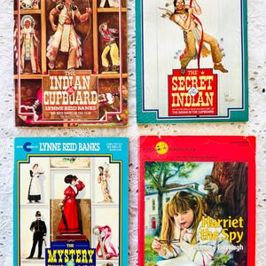 Puede incluir: Cuatro libros de bolsillo con portadas ilustradas. Arriba a la izquierda: The Indian in the Cupboard. Arriba a la derecha: The Secret of the Indian. Abajo a la izquierda: The Mystery of the Cupboard. Abajo a la derecha: Harriet the Spy.