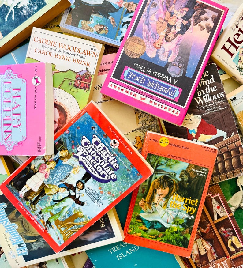 Puede incluir: Una colecci&oacute;n de libros de bolsillo antiguos que incluye t&iacute;tulos como A Wrinkle in Time, Caddie Woodlawn, Mary Poppins, Charlie and the Chocolate Factory, Harriet the Spy, The Wind in the Willows y Treasure Island con portadas ilustradas.