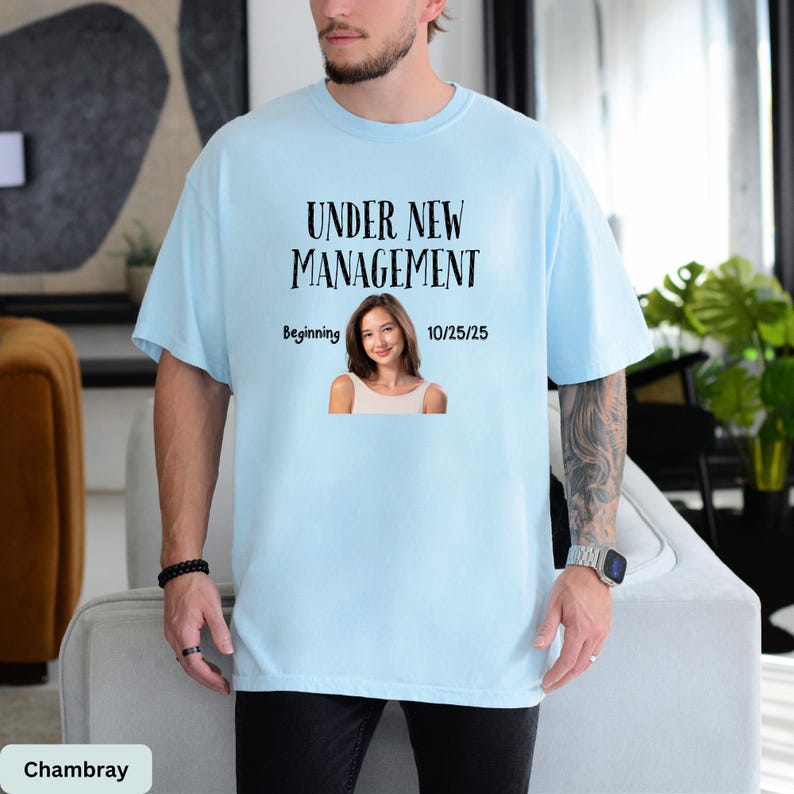 a man wearing a t - shirt that says under new management