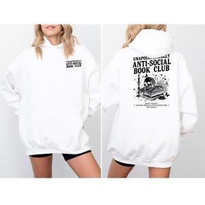 A white hoodie with black text and graphics on the back.