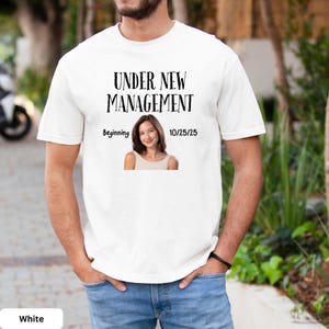 a man wearing a white t - shirt with a picture of a woman on it