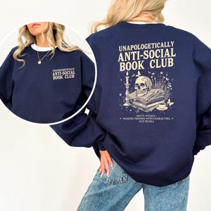 A woman wearing a navy blue sweatshirt with text and graphics on the back.