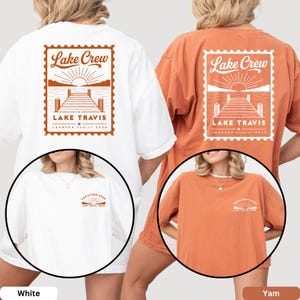 May include: Two short-sleeve t-shirts in white and yam orange. The back features a stamp-shaped graphic with a lake, dock, sun, and text reading Lake Crew, Lake Travis, Johnson Family 2025. The front chest has a small graphic with Vacation 2025.