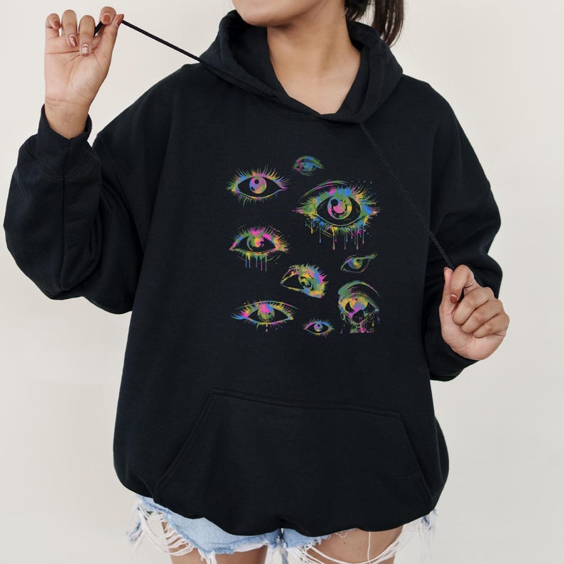 a woman wearing a black hoodie with colorful eyes on it