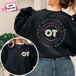 Puede incluir: Una sudadera negra de cuello redondo con un gráfico circular en la espalda con el texto "MOTIVATED COMPASSIONATE OCCUPATIONAL THERAPY EDUCATED PASSIONATE DEDICATED" y "OT" en el centro. La parte delantera tiene un pequeño logo "OT".