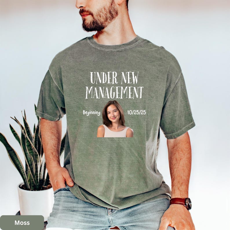a man wearing a t - shirt that says under new management