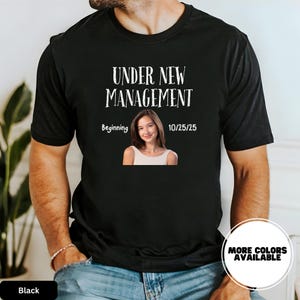 a man wearing a black t - shirt with a picture of a woman