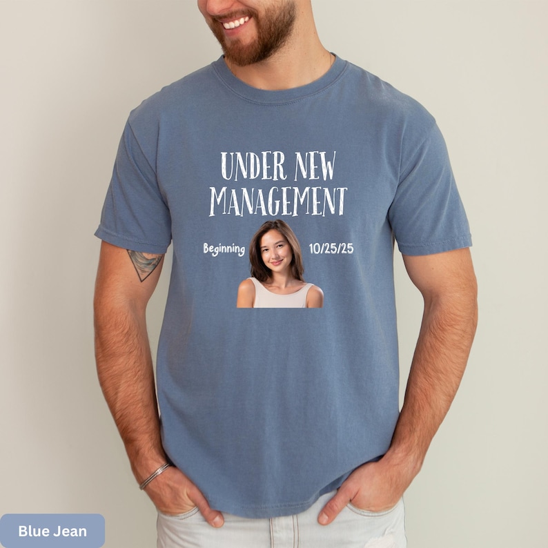 a man wearing a t - shirt that says under new management