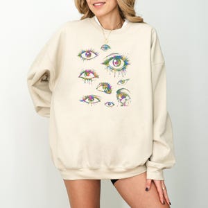 a woman wearing a sweatshirt with an eye print on it