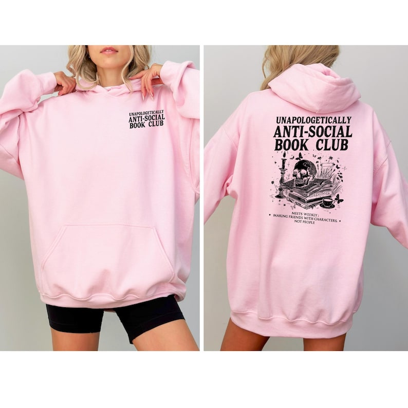 A woman wearing a pink hoodie with text and graphics on the back.