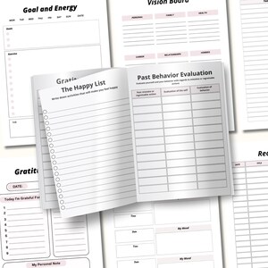 May include: Open planner with various pages for goal setting, gratitude, and self-reflection. The pages include sections for daily goals, exercise, and a "Happy List" to write down activities. The planner has a clean, minimalist design.