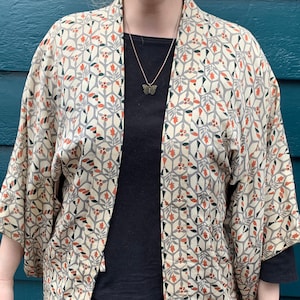 Vintage silk short kimono jacket (haori) in perfect condition: cream with orange, silver and black design. Classic and elegant with a twist!