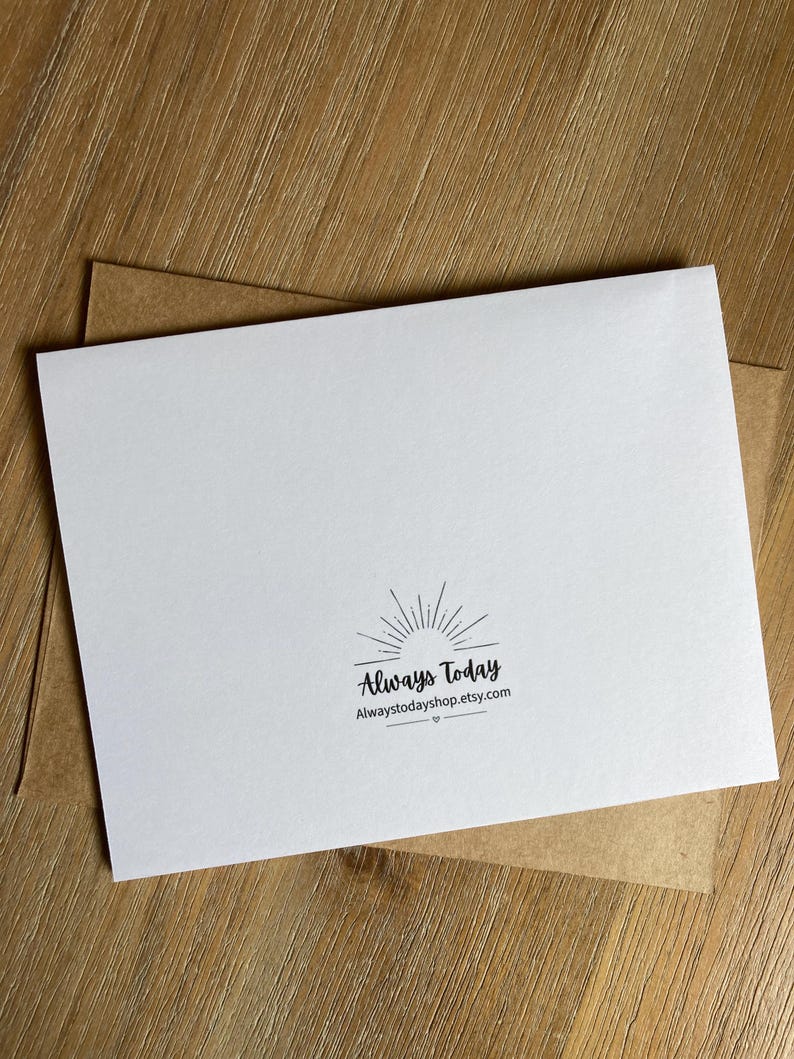 May include: A white rectangular greeting card featuring a black sunburst graphic and the text Always Today followed by the URL Alwaystodayshop.etsy.com, positioned on top of a brown kraft paper envelope.