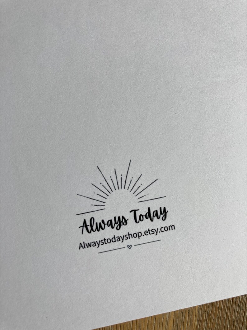 May include: A white paper surface featuring a black ink stamp design. The graphic includes a sunburst icon above the text Always Today, followed by the web address Alwaystodayshop.etsy.com and a small heart symbol centered between two horizontal lines.