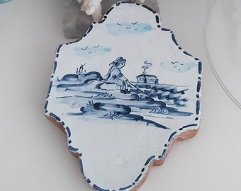 Big Delph tile in a scalloped shape depicting a fishing man on the edge of the river   Blue and white Antique dutch tile