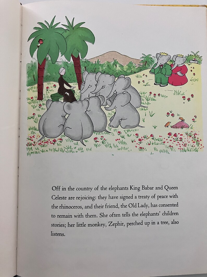 May include: A black and white illustration of a group of elephants gathered around a woman in a green dress. The elephants are sitting on a grassy hill with red flowers. The woman is telling a story to the elephants. The text in the image reads: "Off in the country of the elephants King Babar and Queen Celeste are rejoicing: they have signed a treaty of peace with the rhinoceros, and their friend, the Old Lady, has consented to remain with them. She often tells the elephants' children stories; her little monkey, Zephir, perched up in a tree, also listens."