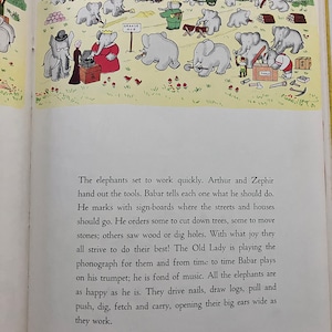 May include: An illustration from a children's book showing a group of elephants working on a construction project. The elephants are using tools and materials to build a town. The text in the image reads "GRANDE AVE" and "TOOLS".