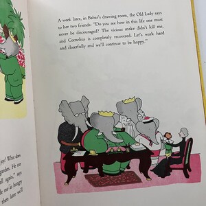 May include: A group of elephants, including Babar, are sitting around a table in a drawing room. The Old Lady is speaking to them, saying, "Do you see how in this life one must never be discouraged? The vicious snake didn't kill me, and Cornelius is completely recovered. Let's work hard and cheerfully and we'll continue to be happy."