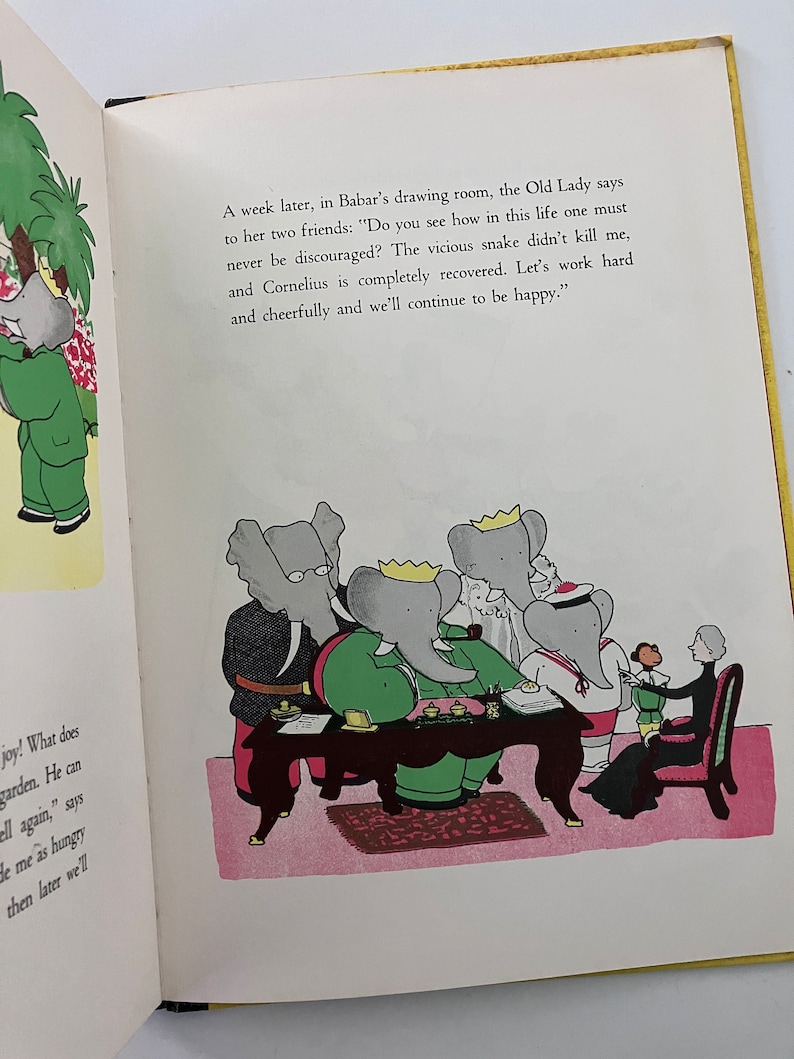 May include: A group of elephants, including Babar, are sitting around a table in a drawing room. The Old Lady is speaking to them, saying, "Do you see how in this life one must never be discouraged? The vicious snake didn't kill me, and Cornelius is completely recovered. Let's work hard and cheerfully and we'll continue to be happy."