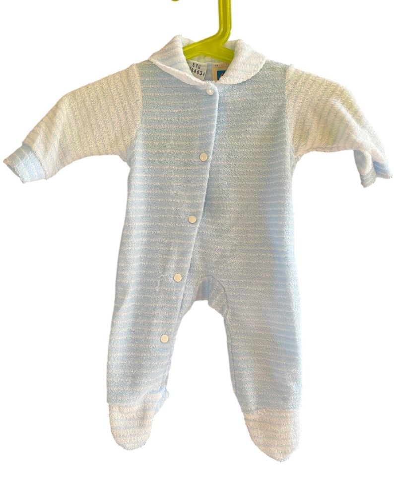 Może przedstawiać: Niemowlęcy pajacyk w niebiesko-białe paski z kołnierzykiem i zapięciem na guziki. Długi rękaw ma stopy i wisi na zielonym wieszaku. Pajacyk wykonany jest z miękkiej, teksturowanej tkaniny.