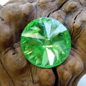 May include: A round, faceted, green crystal with a starburst pattern.