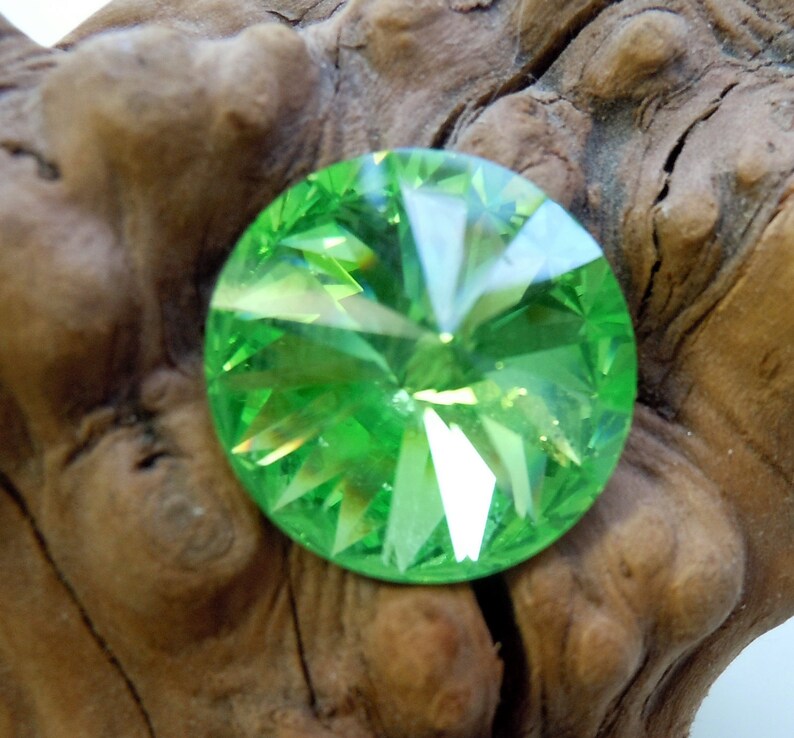 May include: A round, faceted, green crystal with a starburst pattern.