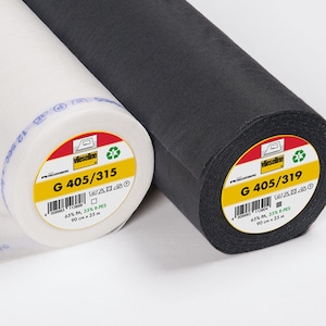 Könnte beinhalten: Zwei Rollen Vlieseline Einlagestoff, eine weiße und eine schwarze. Jede Rolle hat ein gelbes Etikett mit dem Produktcode G 405/315 oder G 405/319, einem Barcode, Pflegesymbolen und den Angaben 65% PA, 35% R-PES, 90 cm x 25 m.