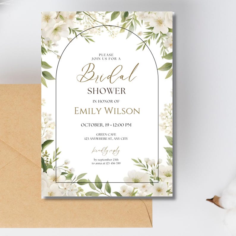 May include: Bridal shower invitation with floral and greenery design. The invitation features the text "Bridal Shower" and details for Emily Wilson's shower, including the date, time, and location. The invitation is surrounded by white flowers and green leaves.