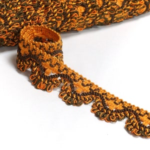 May include: Brown and gold trim with a scalloped edge. The trim is made of a woven fabric with a textured design.