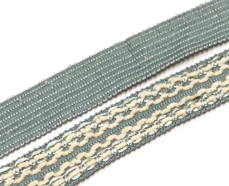 May include: Two pieces of trim, one with a simple woven design and the other with a more intricate design featuring a white thread and silver accents.