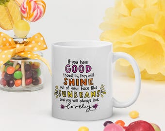 May include: White ceramic mug with the text "If you have GOOD thoughts, they will SHINE out of your face like SUNBEAMS and you will always look lovely." The mug is surrounded by colorful candies and a jar of sweets.