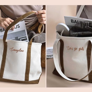 Peut inclure: Un sac fourre-tout en toile blanche avec des finitions et des anses en cuir marron. Le sac porte deux inscriptions brod&eacute;es diff&eacute;rentes : "Evangeline" et "Let's go girls".