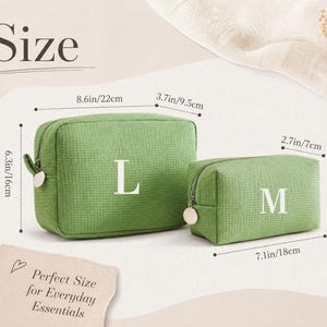May include: Two green textured fabric pouches with zipper closures. The larger pouch is labelled with an L and measures 22 cm by 16 cm by 9.5 cm. The smaller pouch is labelled with an M and measures 18 cm by 11 cm by 7 cm.