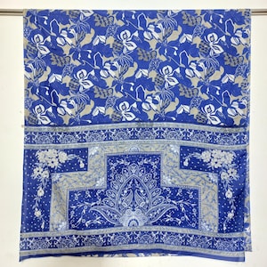 May include: A blue and white patterned fabric with a floral design. The fabric has a border with a paisley pattern.