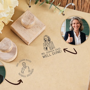 Pode incluir: Carimbos de madeira com o texto "Ms. Sophia disse Bem feito!" e "Mr. James disse Bem feito!" são exibidos em uma superfície bege. Os carimbos têm uma alça de madeira e um design de carimbo circular. A imagem também inclui uma foto de uma mulher e um homem.