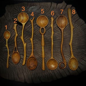 Puede incluir: Ocho cucharas de madera con mangos únicos de ramas naturales. Las cucharas son todas de diferentes formas y tamaños, y están dispuestas en una fila sobre una superficie de madera. Las cucharas están hechas de madera natural y tienen un aspecto rústico y hecho a mano.