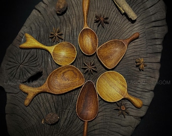 Puede incluir: Conjunto de seis cucharas de madera de diferentes formas y tamaños. Las cucharas están hechas de madera marrón oscura y tienen un acabado natural. Las cucharas están dispuestas en círculo sobre una superficie de madera.