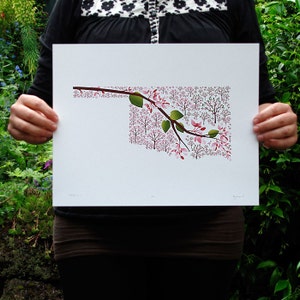 May include: A white print of the state of Oklahoma outlined with a branch of pink blossoms and green leaves.