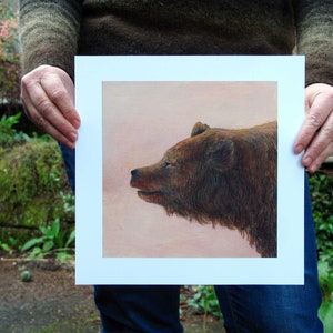 May include: A close-up of a brown bear's head and neck, painted in a realistic style. The bear is looking to the right, with its mouth slightly open. The background is a soft, peachy pink.