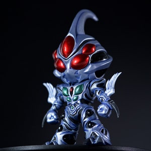 Puede incluir: Figura estilizada de una criatura con una cabeza bulbosa y múltiples ojos rojos. La figura es principalmente azul con detalles plateados y verdes en el pecho. Tiene apéndices afilados en forma de garra y se apoya en una base negra.