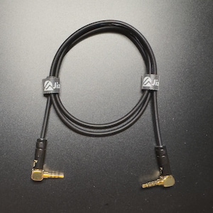 Peut inclure: Câble audio noir avec connecteurs dorés. Le câble est enroulé et comporte deux bandes blanches avec un logo. Les connecteurs sont coudés. Conçu pour les équipements audio.